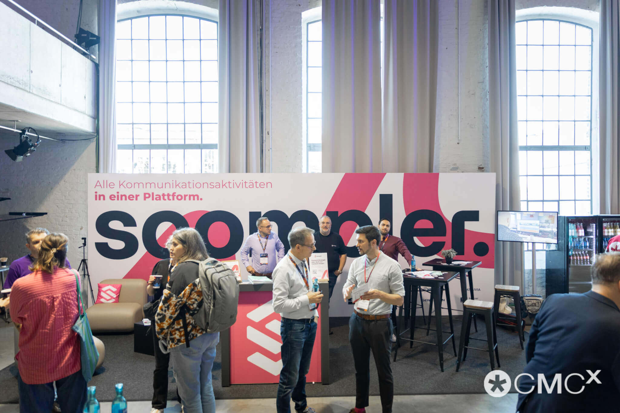 Besucher engagieren sich beim Networking-Event CMCX am Scoompler-Stand, ein erfolgreiches Business-Event.