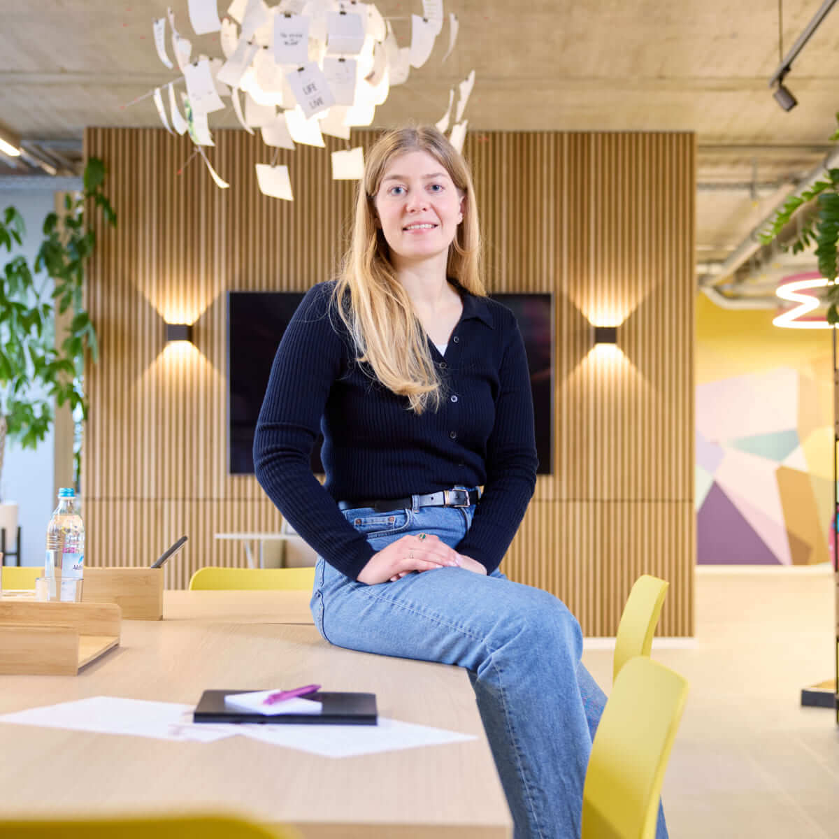 Elenia Wolf, Head of Marketing at Scompler, presents herself dynamically in a modern office environment.