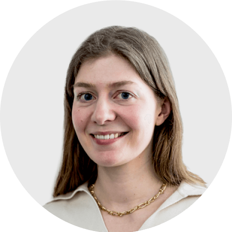 Elenia Wolf, lächelnd im professionellen Headshot, als Scompler-Expertin mit langem Haar und goldener Kette.