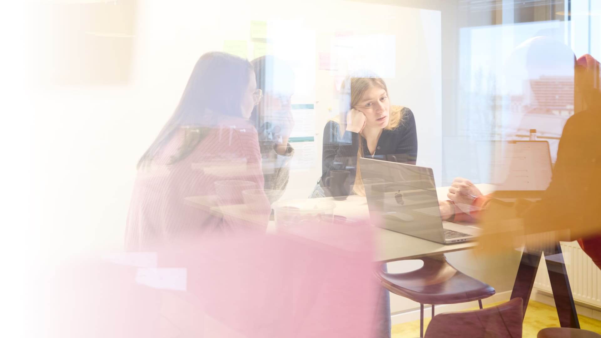 Kreatives Team im New Work-Büro, engagiert in effektiver interner Kommunikation am Laptop.