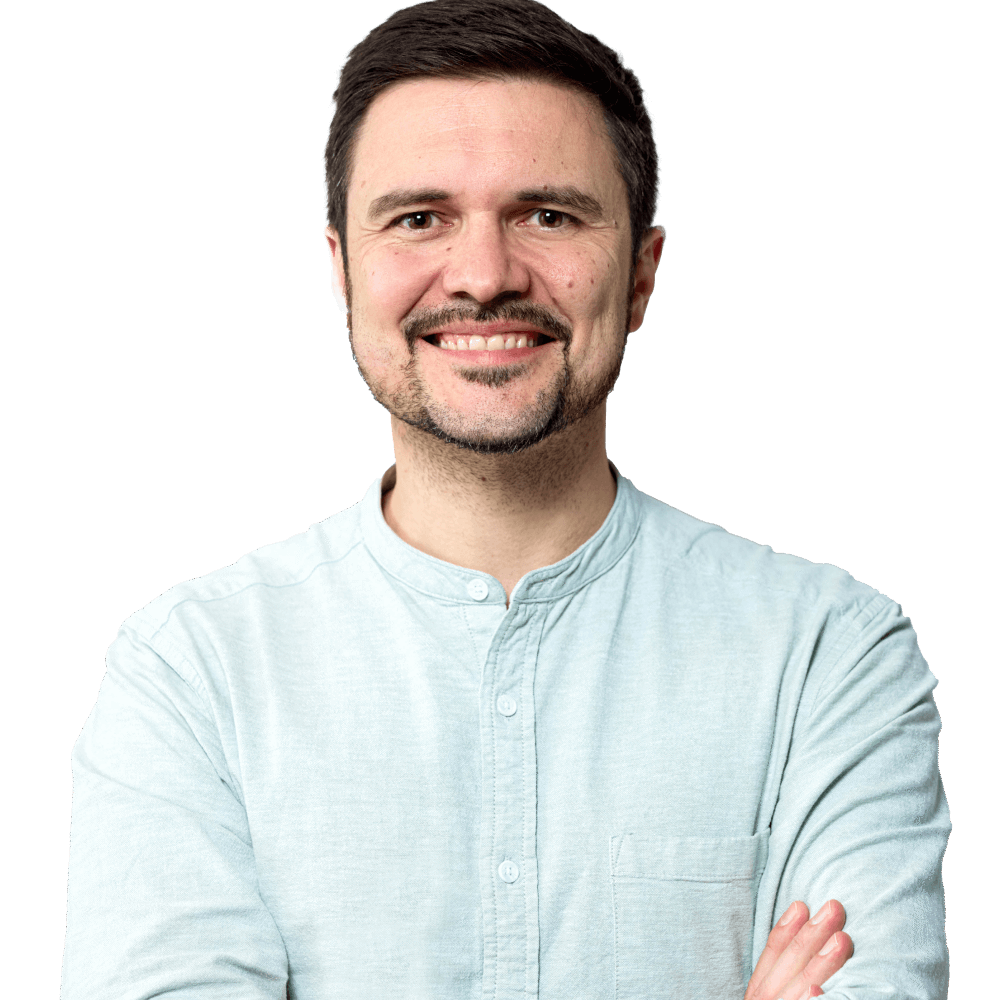 Der Content-Stratege Max Miguletz, Gr&uuml;nder von Scompler, l&auml;chelt freundlich mit verschr&auml;nkten Armen.