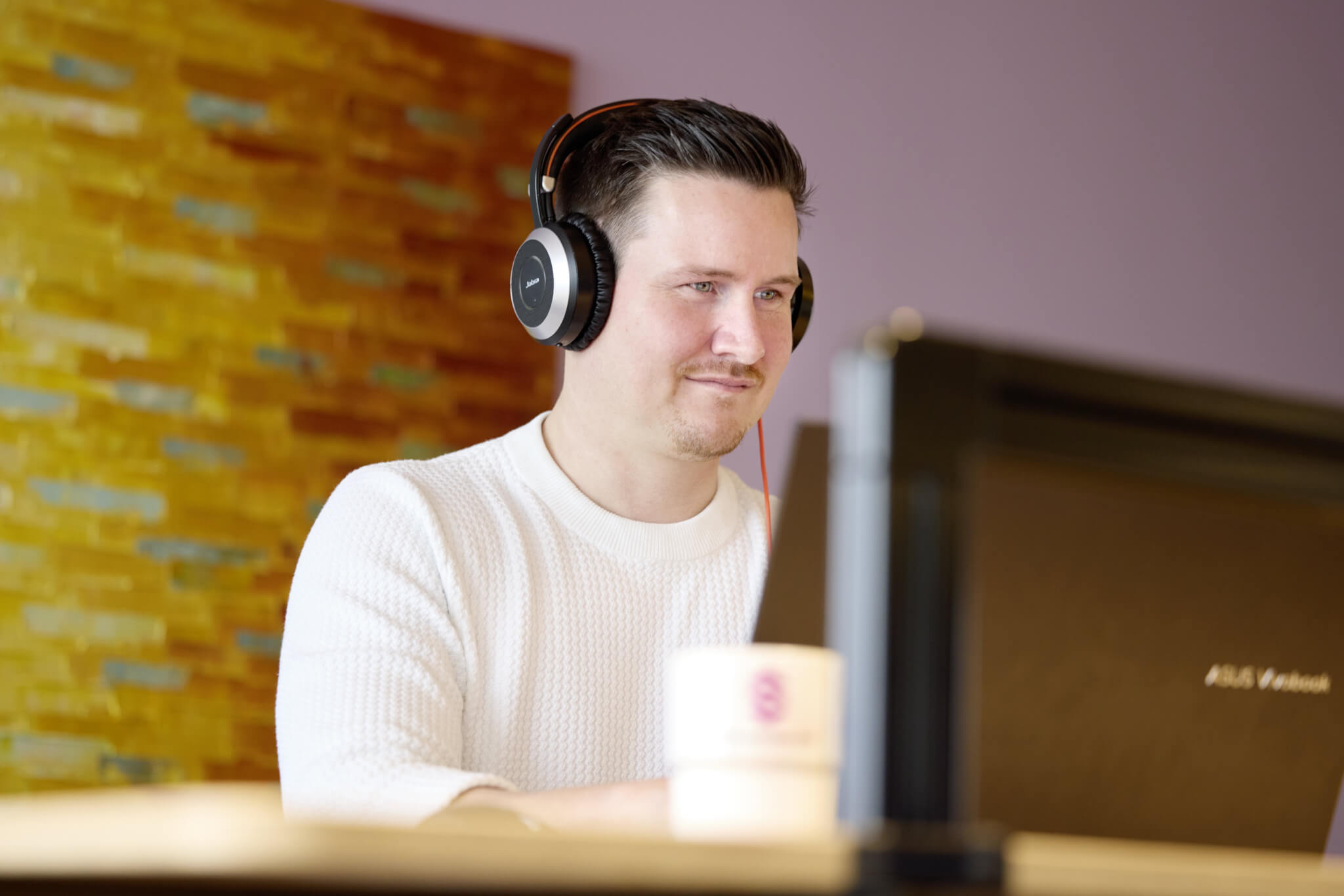 Scompler employees wearing headphones while working productively from home.
