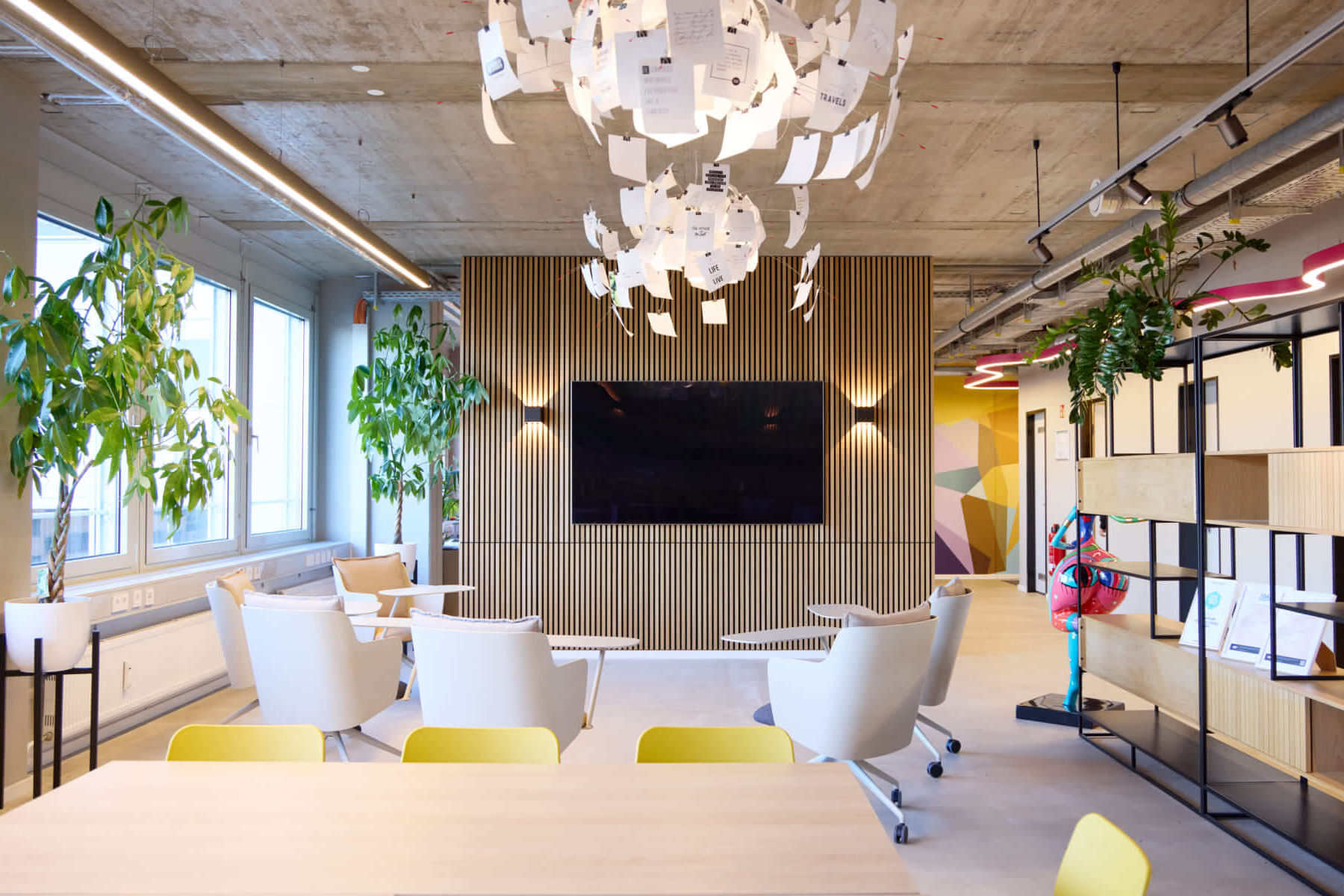 Karriere bei Scompler: Unsere offenen Stellen 8 Kreatives Scompler Büro München: New Work Lounge mit Papierskulptur-Leuchte, Pflanzen und modernem Multimedia-Bereich.