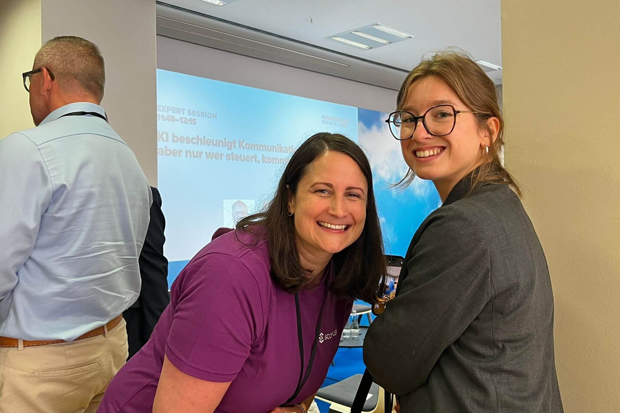 Scompler Team beim Kommunikationskongress in Berlin vor einer Präsentation über KI-gesteuerte Kommunikation und Vernetzung.