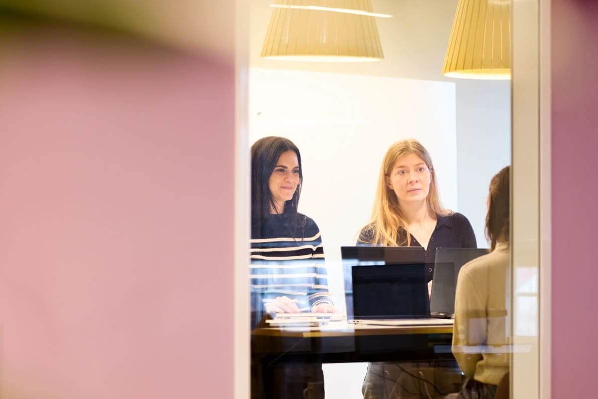 Über Scompler 9 Engagiertes scompler team bespricht Projekte im hellen office münchen. Kolleginnen arbeiten effektiv zusammen.