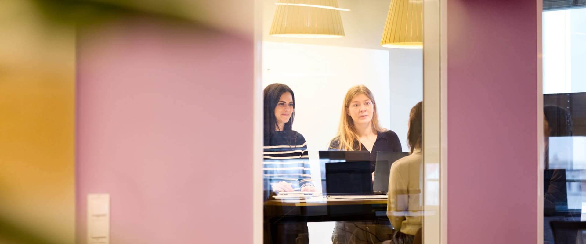 Scompler Team: Dynamische Köpfe im Office München 15 Engagiertes scompler team bespricht Projekte im hellen office münchen. Kolleginnen arbeiten effektiv zusammen.