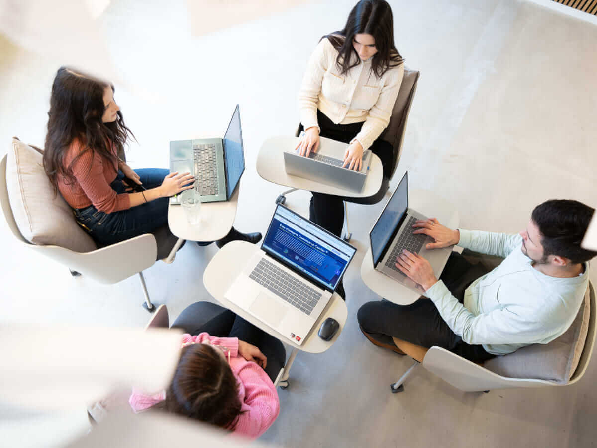 Moderner Arbeitsplatz: Teamarbeit & Produktivität mit Laptops 13 Vier Kollegen arbeiten mit Laptops an einem modernen Arbeitsplatz. Effiziente Teamarbeit in offener Umgebung.